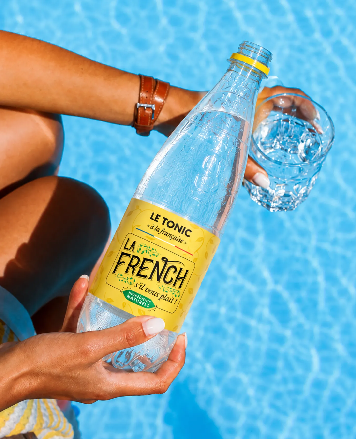 Bouteille Le Tonic La French tenue à la main, près d'un verre sur glace